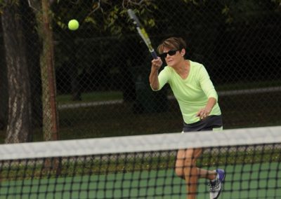 senior woman playing tennis outside